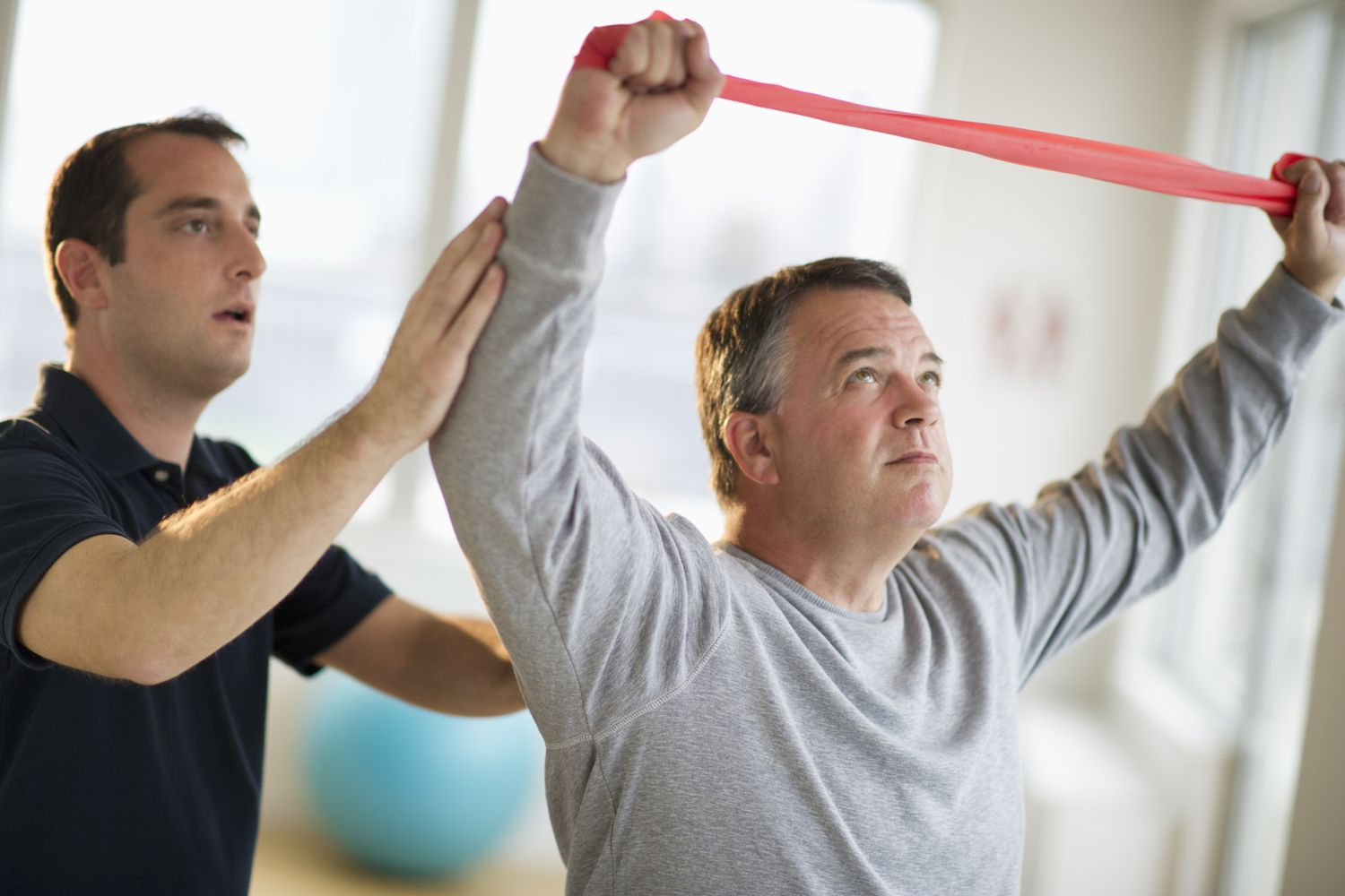 Physiotherapist guiding a patient through a resistance band exercise