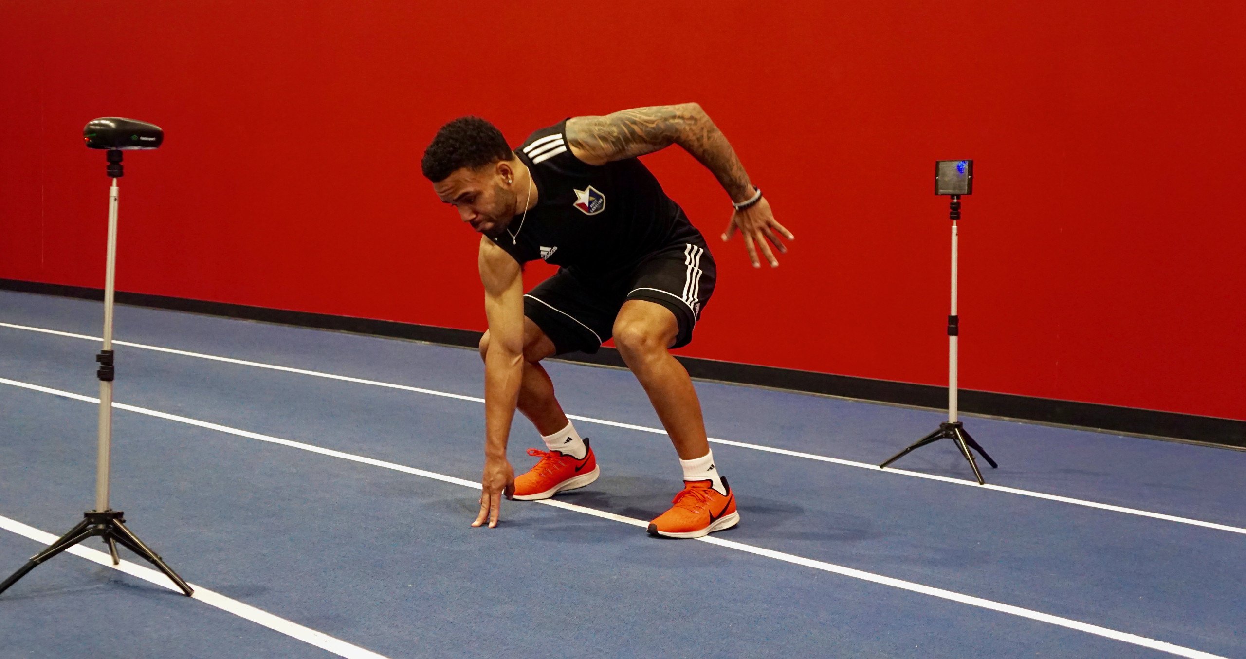 Athlete performing speed test with bio-sensor tripods measuring movement