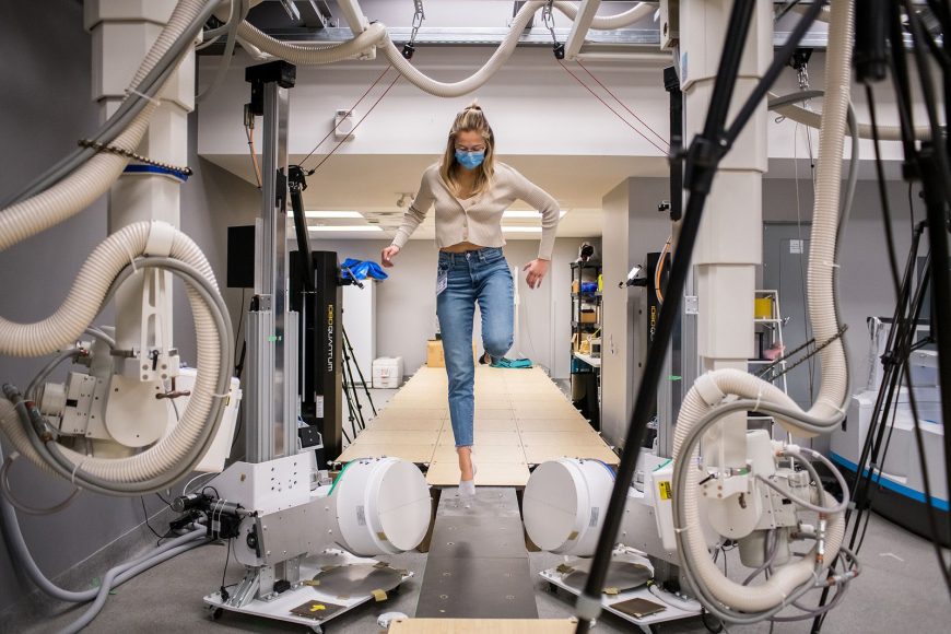 Research participant walking through gait analysis laboratory with sensor equipment